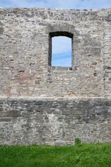 Old, historical and antique wall made of stone.  Facade with window. Minimalist detail of aged architecture and building.