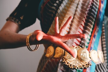 Close up view on the red colored hand showing Alapadma hasta mudra. Full blossom lotus gesture....