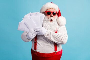 Portrait of his he nice attractive amazed wondered overwhelmed thick white-haired Santa holding in hand many mail gift wish list lottery isolated bright vivid shine vibrant blue color background