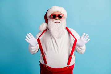 Fototapeta na wymiar Portrait of his he nice attractive cheerful cheery funky comic white-haired Santa pulling suspenders having fun fooling good mood isolated over bright vivid shine vibrant blue color background