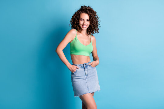 Photo lovely nice cute girlish lady woman beaming smile look direct camera summer flirty outfit clothes brand advert concept wear green top denim skirt isolated pastel blue color background