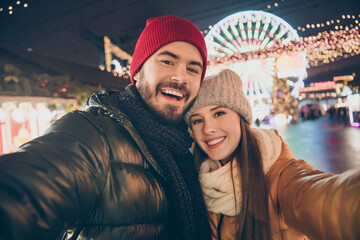 Photo of affectionate couple make selfie on x-mas christmas season town event wear winter coats hats scarf