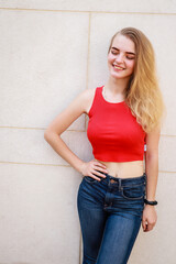 Portrait shooting of a stylish girl. Beige shades. Trends of spring and summer 2020.Black pants and red crop top.