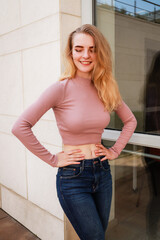 Portrait shooting of a stylish girl. Beige shades. Trends of spring and summer 2020.Black pants and beige crop top.