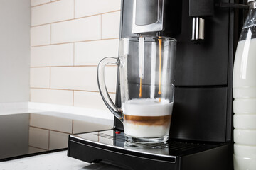 glass glass of cappuccino is prepared in the coffee machine at home