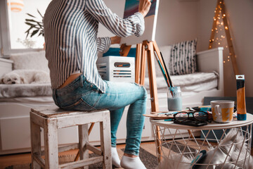 Beautiful artist woman painting in her room.