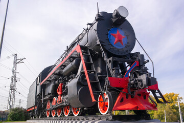 old locomotive stands on a pedestal as a monument