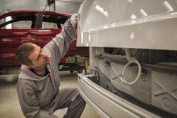 an employee of the body painting workshop checks the quality.