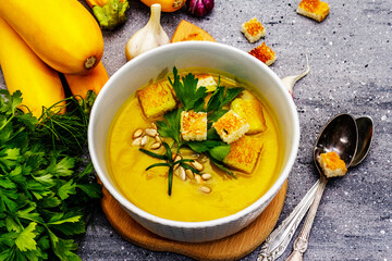 Yellow zucchini cream soup. Healthy vegan (vegetarian) food, crispy toast, sunflower seeds, whole ripe fruits, fresh greens