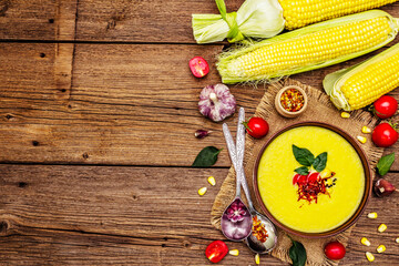 Corn cream soup with fresh vegetables, herbs and spices