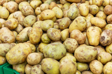 Potatoes on the counter in the vegetable section of the supermarket. Close-up. Background.