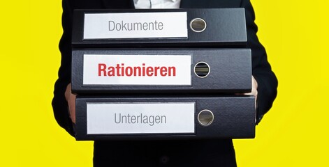 Rationieren. Mann trägt Stapel Ordner. Aktenordner haben Beschriftung mit Text. Hintergrund gelb.