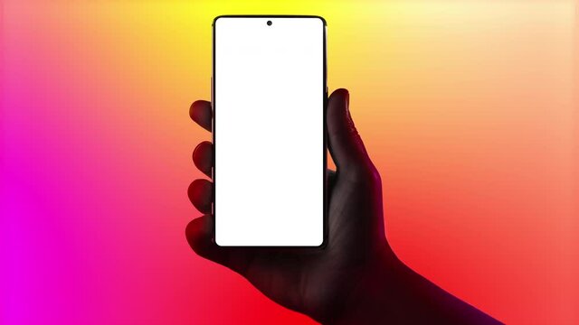 Hand holding phone. Silhouette of male hand holding smartphone isolated on multicolored background. Bezel-less screen. Cinemagraph, seamless loop