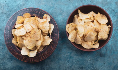 Potato chips on a plate. Wooden table. Salty food for beer