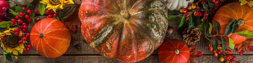 Festive autumn background, with traditional decor - pumpkins, berries, fruits, leaves on old wooden...