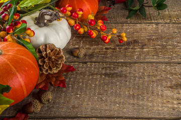 Festive autumn background, with traditional decor - pumpkins, berries, fruits, leaves on old wooden...