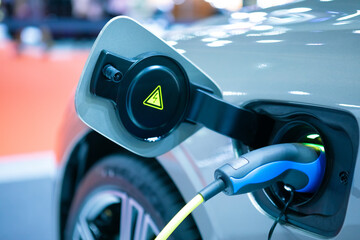Close up plug power vehicle electric EV car charge battery energy in the station. Green eco...