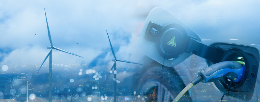 Double exposure of EV electric car charge battery and wind turbine, uses nature electric energy to generate electricity. Bokeh blur light building cityscape panoramic on background. Green eco concept.