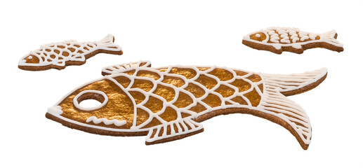 Sweet golden fishes from Christmas gingerbread isolated on white background. Cute gold cookies for good luck. Baked little and big fish shaped animals. Traditional ornate Xmas pastry of Czech cuisine.