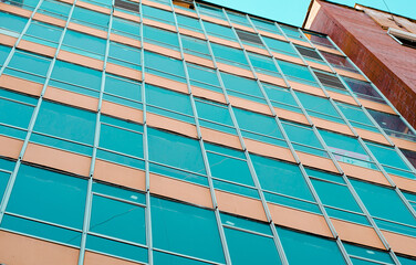 The building has many Windows. Glazing of a new multi-storey building. Modern urban architecture. The facade of the building with blue glass.