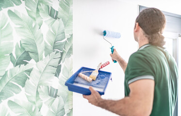 Maler streicht die Wand mit Tapetenkleister ein