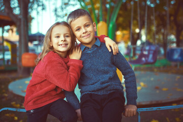 boy embraces girl happy face on a background of public park