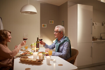Family of two sitting at the table drinking wine and eating dinner they have date at home