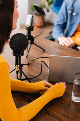 cropped view of broadcaster interviewing woman in radio studio