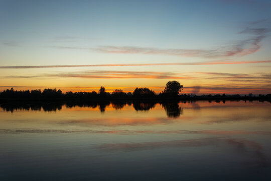 Clouds mirrored in the lake water after sunset © darekb22