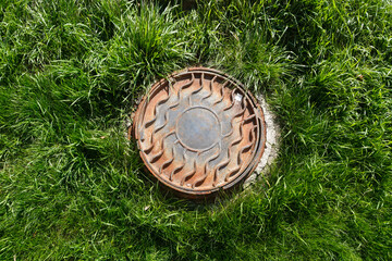 Metal manhole on the lawn