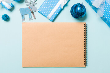 Top view of notebook on blue background made of Christmas decorations. New Year time concept