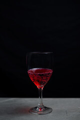 Glass with red water on bar, Alone in the dark.