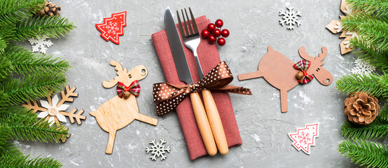 Top view Banner of flatware tied up with ribbon on napkin on cement background. Close up of christmas decorations and reindeer. New Year holiday concept