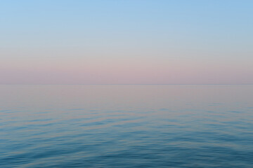 Blue and purple gradient of the sky and sea in the evening. Calm sea wavy surface