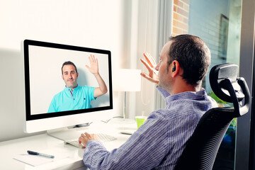 Man in front of computer having video conference call with coworker