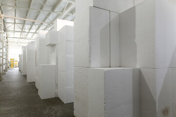 Industrial production of polystyrene foam insulation panels or plates from expanded polystyrene. A large blocks of Styrofoam are stacked in a warehouse. Building materials.