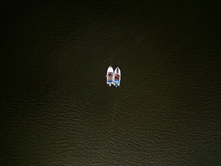 Obraz na płótnie Canvas A fisherman on a boat on the river. Aerial top shot.