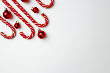 Candy canes and red Christmas baubles on white