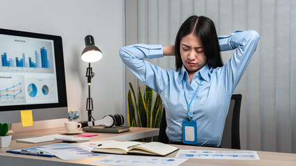 Young Asian Business woman sitting on the chair stretching herself and exercise for relaxation while working hard at office