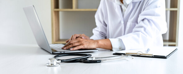 Doctor working with laptop checking patient history form while think about finding a cure for a diagnosis, treatment methods to rehabilitate the body recommend treat of patient