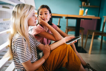 Two young women talking in a room about problems