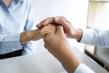 Doctor touching patient hand for encouragement and empathy on the hospital, cheering and support patient