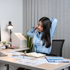 Young Asian Business woman sitting on the chair stretching herself and exercise for relaxation...