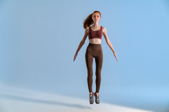 Photo of athletic focused sportswoman jumping while working out
