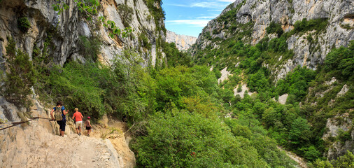 Hikers in the Verdon canyon, walking along the deep lying Verdon river on the famous Martel hiking...