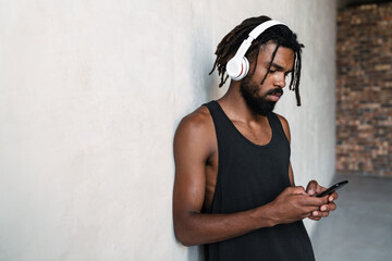 Fototapeta premium Image of african american sportsman using cellphone and headphones