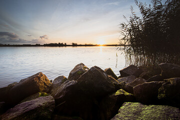 View of a dutch river from the waterfront during sunrise
