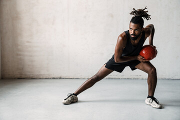 Image of african american sportsman working out with medicine ball