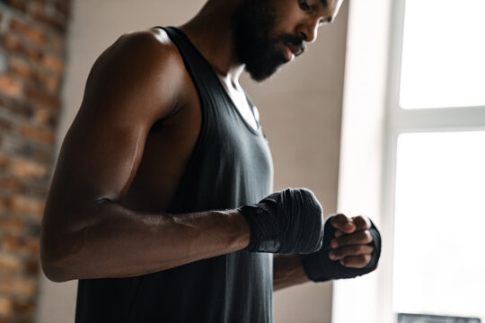 Image of athletic african american sportsman boxing in hand bandage