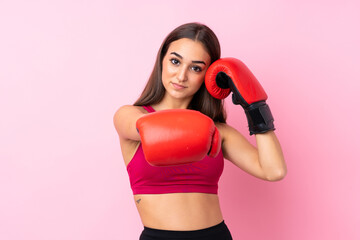 Young sport girl over isolated pink background with boxing gloves